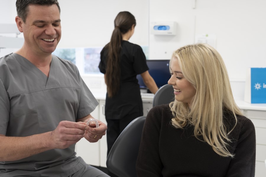dentist showing patient Invisalign clear aligners